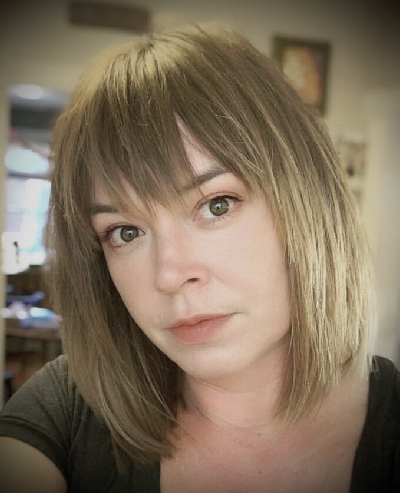 A woman with brown hair and bangs wearing black shirt.