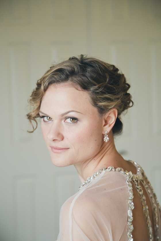 A woman with short hair and wearing earrings.